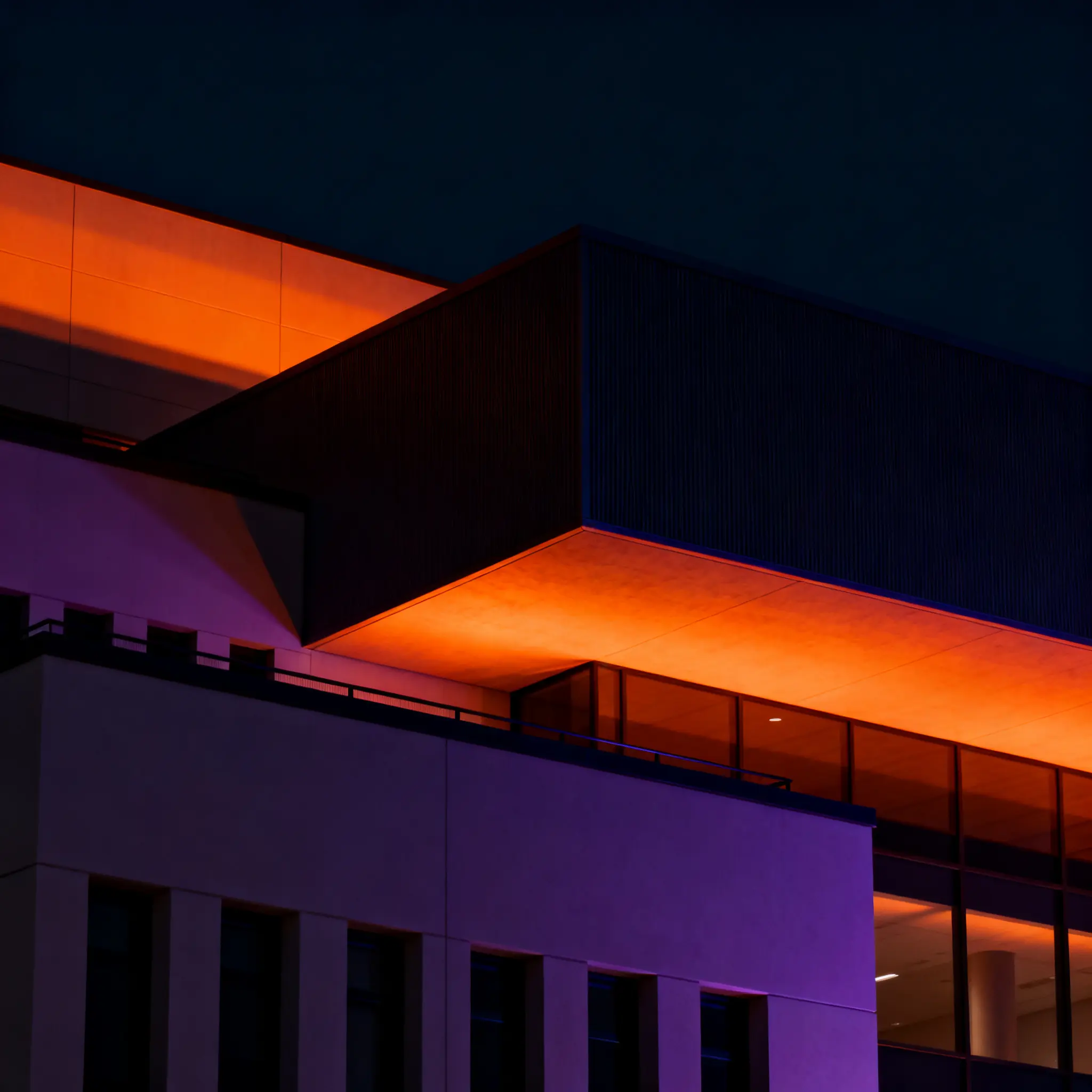 Modern office building illuminated with warm and purple lighting at night